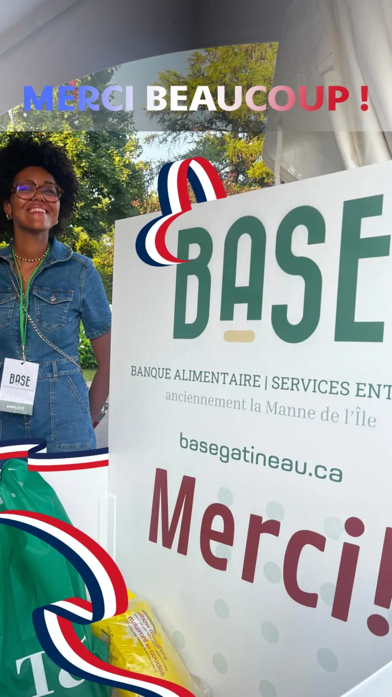 Lyonna, employée de la BASE Banque Alimentaire de Gatineau, souriante devant une boîte de dons lors de la collecte solidaire organisée avec l’Ambassade de France au Canada, le 14 juillet 2025.